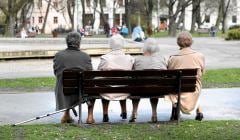 Emerytki siedzące na ławce w parku.