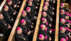 Biskupi siedzą w kościelnych ławach