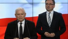 Stoją Jarosław Kaczyński stoi przy mównicy, z tyłu Zbigniew Ziobro