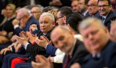 Jarosław Kaczyński siedzi, patrzy w bok w stronę kamery, na pierwszym tle marek Suski i Antoni Macierewicz