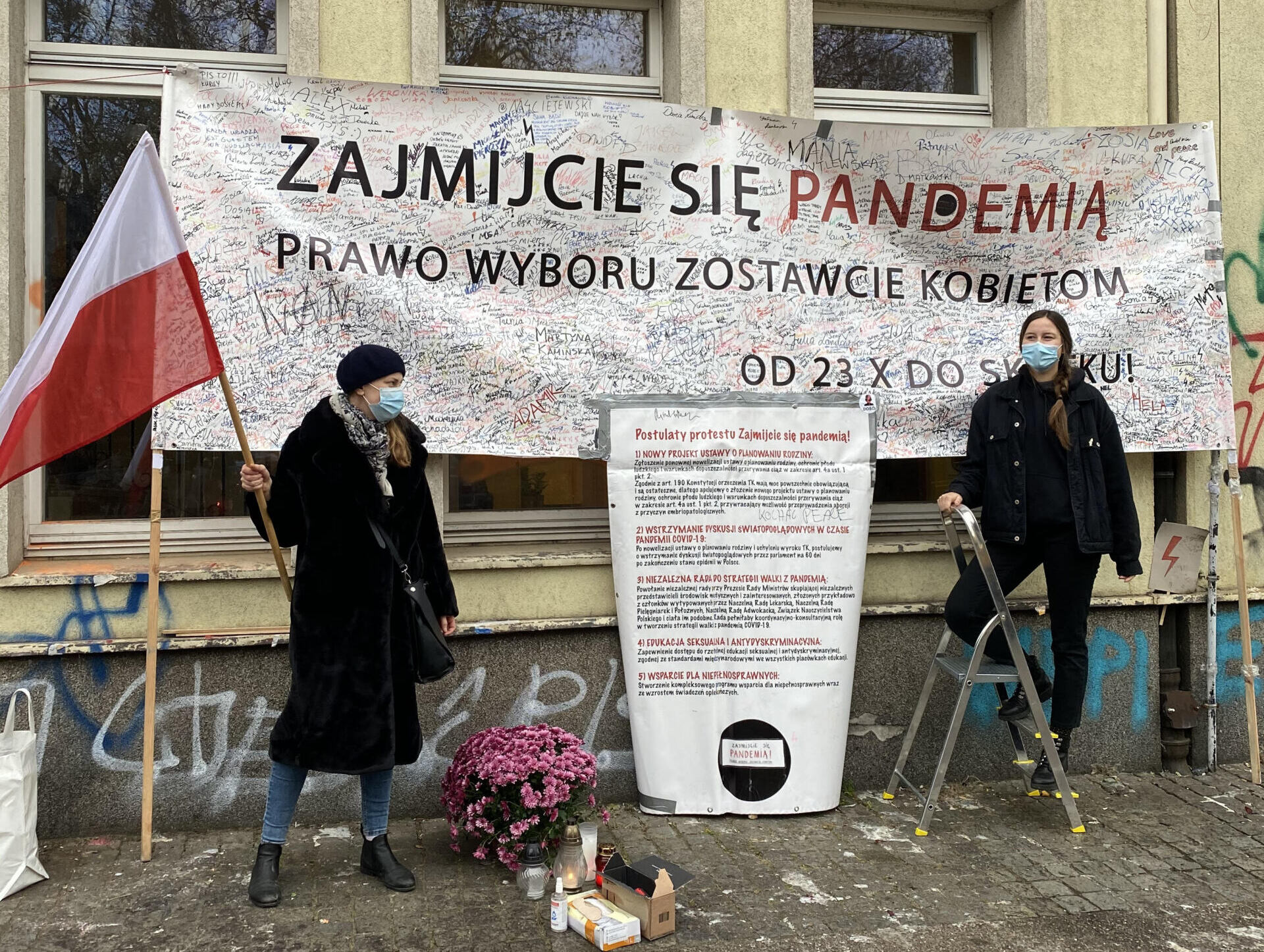 Kobiety pod transparentem "Zajmijcie się pandemią, wybór zostawcie kobietom" zapisanym dodatkowymi hasłami