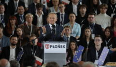Donald Tusk przemawia na konwencji PO w Płocku, trzyma przed sobą rozłożone dłonie