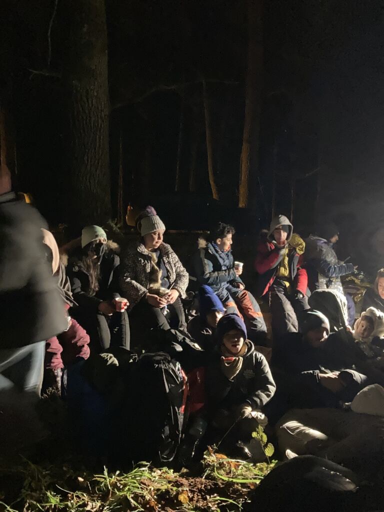 uchodźcy na granicy polsko-białoruskiej spożywają posiłek dostarczony przez aktywistów