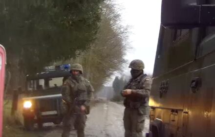 Wojskowy pojazd i żołnierze w hełmach na ulicy