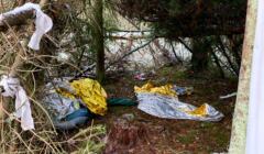 Porzucone przez migrantów rzeczy leżą na ziemi w lesie