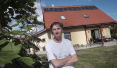 Damian Nowicki na tle dachu swojego domu, gdzie zamontował panele po dofinansowaniu z funduszu europejskiego, wieś Rokitnica