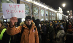 Młody człowiek trzyma napis po rosyjsku „niet wojnie
