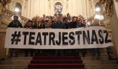 Zespół Teatru trzyma baner z napisem 