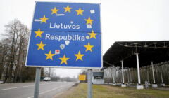 Niebieska tablica z napisem Lietuvos Respublika. Napis otoczony złotymi gwiazdkami unijnymi