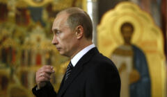 Władimir Putin żegna się na tle złotej ikony