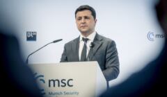 Mężczyzna w garniturze przemawia, przed logo MSC