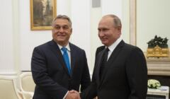 Dwaj mężczyźni ściskają sobie dłonie patrząc do kamery. To Viktor Orban i Władimir Putin