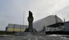 Pomnik przed sarkofagiem kryjącym zniszczony reaktor w Czernobylu