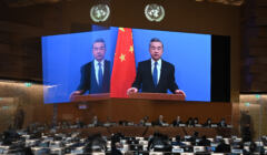 Szef chińskiego MSZ Wang Yi na ekranie przemawia w ONZ, obok chińska flaga