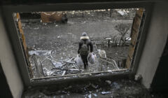 Młoda kobieta ucieka ze zniszczonego budynku. Kijów, Ukraina