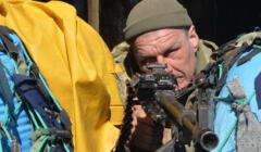 Ukraiński żołnierz celuje z broni na checkpoincie w Charkowie