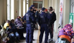 Policjanci rozmawiają z ciemnoskórym mężczyzną w hali dworca w Przemyślu