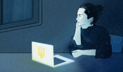 Zamyślona kobieta, która siedzi w ciemnym pokoju przed laptopem z naklejką ukraińskiego tryzuba