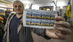 Kijów, Ukraina, 15.04.2022. Mieszkaniec Kijowa pokazuje znaczki pocztowe przedstawiające ukraińskiego żołnierza pokazującego środkowy palec rosyjskiemu krążownikowi