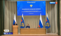 Męzczyzna na mównicy (Putin), pozostali - w prezydium, z tyłu rosyjskie flagi
