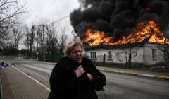 Kobieta płacze stojąc przed płonącym domem po tym, jak została ostrzelana w mieście Irpień pod Kijowem 4 marca 2022 r.