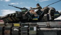Ukraiński żołnierz siedzi na czołgu przewożonym przez transporter niedaleko Bachmutu na wschodniej Ukrainie, 12 maja 2022 r., podczas rosyjskiej inwazji na Ukrainę.