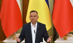 Andrzej Duda przemawia na tle flag Polski i Ukrainy