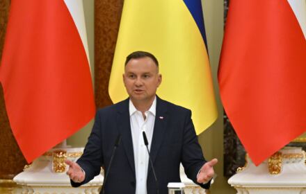 Andrzej Duda przemawia na tle flag Polski i Ukrainy