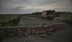 Droga z przerwaną betonową blokadą, na której napisano po ukrainsku 
