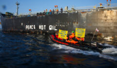 Duży ponton z ludźmi trzymającymi baner przeciw importowi ropy