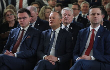 Szymon Hołownia, Donald Tusk i Władysław Kosiniak-Kamysz siedzą obok siebie, patrząc w różne strony