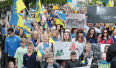 Tłum ludzi z plakatami popierającymi Uklrainę. Sporo osób wz flagami Ukrainy