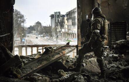 Rosyjski żołnierz filmuje telefonem komórkowym na gruzach teatru w Mariupolu