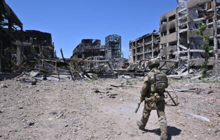 Rosyjski żołnierz patroluje teren wśród ruin budynków