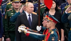 Mężczyzna w garniturze, przed nim żołnierze z wyciągniętymi paradnymi szablami, Władimir Putin