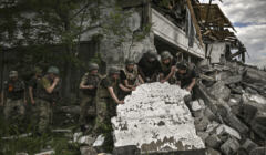 Ukraińscy żołnierze przed zniszczonym budynkiem w Łysyczańsku