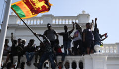 młodzi ludzie demonstrują na balkonie z flagą Sri Lanki