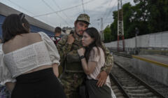 Ukraiński żołnierz żegna się z partnerką na stacji kolejowej w Odessie, 24 lipca 2022, fot. BULENT KILIC / AFP