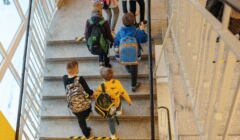 Dzieci z plecakami na schodach w szkole