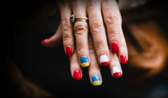 Ręce z pomalowanymi paznokciami w kolory flag: Ukrainy i Polski