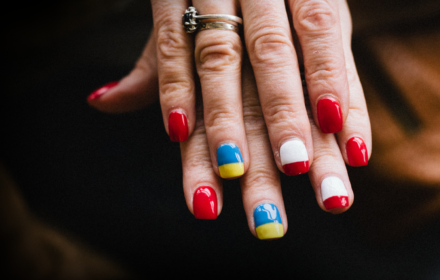 Ręce z pomalowanymi paznokciami w kolory flag: Ukrainy i Polski