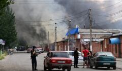 Pracownicy ochrony zatrzymują kierowców, gdy dym unosi się z centralnego rynku w Słowiańsku, na północ od Kramatorska, 5 lipca 2022 roku, po podejrzanym ataku rakietowym w trakcie rosyjskiej inwazji na Ukrainę.