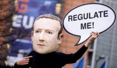 Aktywista ekologicznej organizacji pozarządowej Avaaz w masce przedstawiającej prezesa Facebooka Marka Zuckerberga trzyma transparent z napisem 