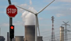 Znak stopu i turbina wiatrowa są widoczne przed elektrownią węglową prowadzoną przez niemieckiego dostawcę energii RWE w Niederaussem, w zachodnich Niemczech, 13 lipca 2022 roku. - W odpowiedzi na ograniczenie dostaw gazu z Rosji Niemcy reaktywowały zamknięte elektrownie węglowe, aby odciążyć gaz.