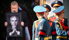 Mężczyzna z portretem Gorbaczowa i żołnierze