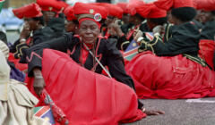 Afrykanki w czerwonych rozkloszowanych spódnicach i czerwonych kapeluszach