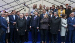 Politycy PiS, między innymi Mateusz Morawiecki, Jarosław Kaczyński, Andrzej Duda, Mariusz Błaszczak,stoją w rzędzie pod namiotem, robiąc sobie selfie