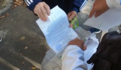 Głosowanie na ulicy. Człowiek do obnośnej urny wkłada karte do głosowania, tak że widać, ze głosował na TAK