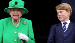 Królowa w zielonym płaszczyku i zielonym kapeluszu obok nastolatek w marynarce i w krawacie,. patrzy na nią z usmiechem